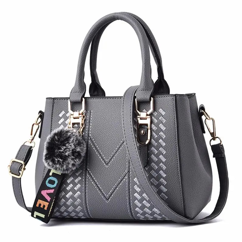 “Embroidered leather handbag for women with hairball detail, stylish and versatile.”