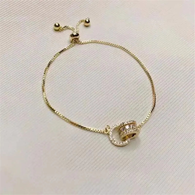 “Trendy Gold-Color Interlocked Circle Bangle, Unisex, Stylish Party Bracelet Accessory.”