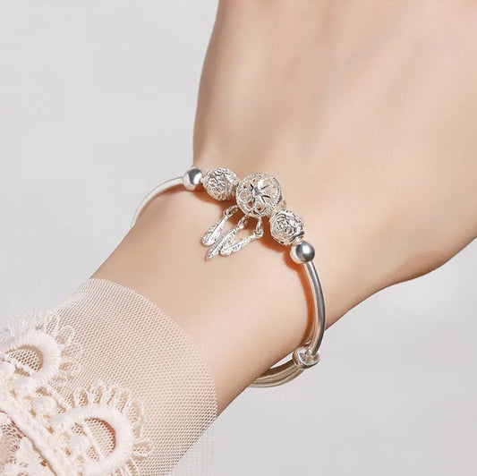 “Silver dreamcatcher tassel feather bracelet, lucky bead bangle, perfect for weddings.”