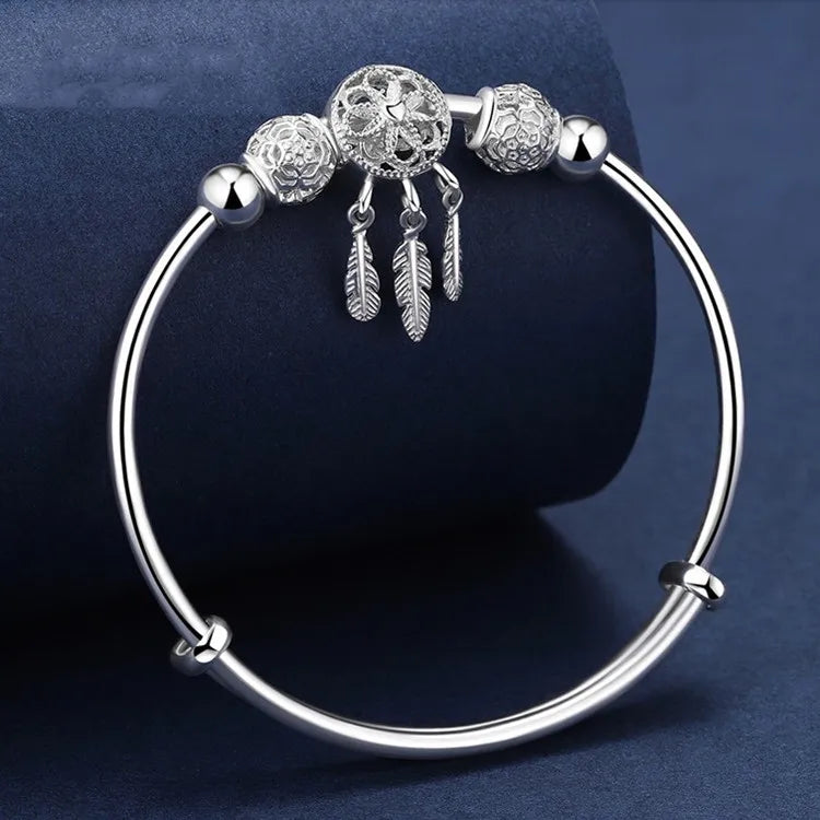 “Silver dreamcatcher tassel feather bracelet, lucky bead bangle, perfect for weddings.”