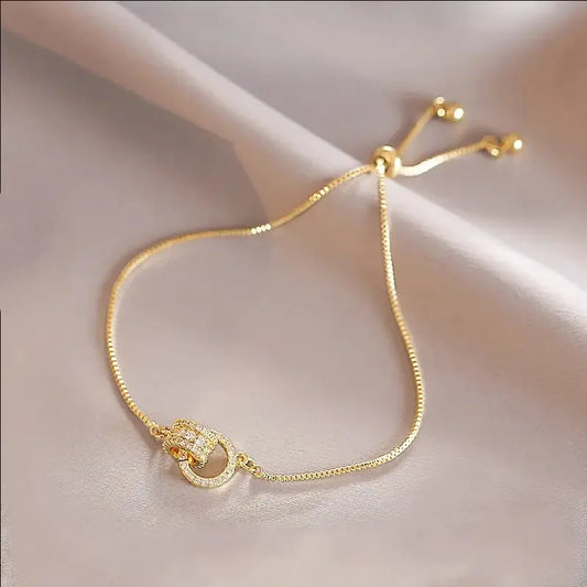 “Trendy Gold-Color Interlocked Circle Bangle, Unisex, Stylish Party Bracelet Accessory.”