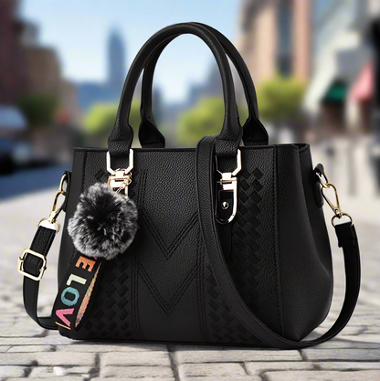 “Embroidered leather handbag for women with hairball detail, stylish and versatile.”