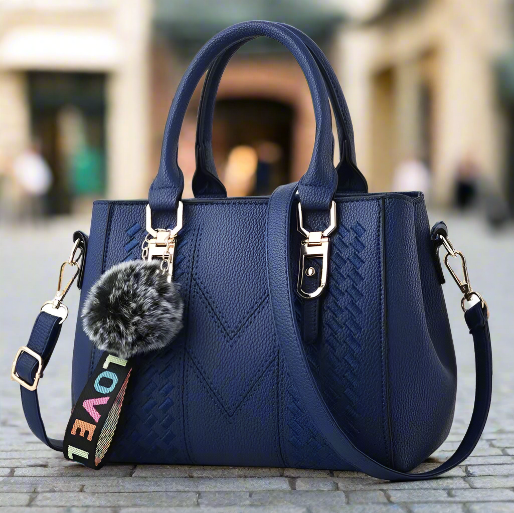 “Embroidered leather handbag for women with hairball detail, stylish and versatile.”