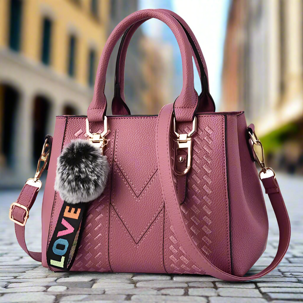 “Embroidered leather handbag for women with hairball detail, stylish and versatile.”