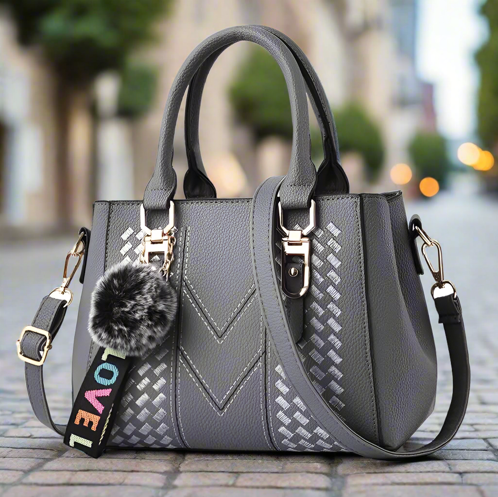 “Embroidered leather handbag for women with hairball detail, stylish and versatile.”