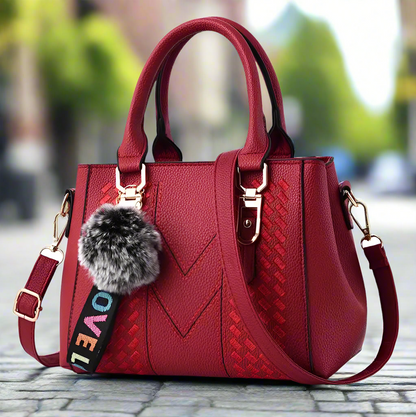 “Embroidered leather handbag for women with hairball detail, stylish and versatile.”