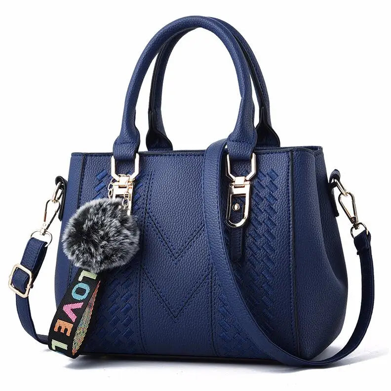 “Embroidered leather handbag for women with hairball detail, stylish and versatile.”