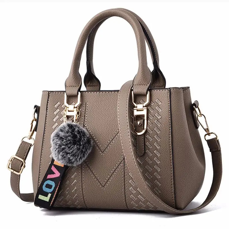 “Embroidered leather handbag for women with hairball detail, stylish and versatile.”
