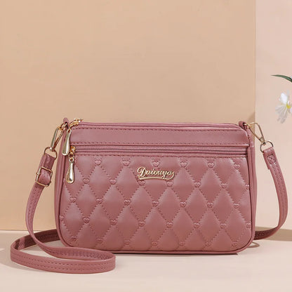 “Embroidered leather handbag for women with hairball detail, stylish and versatile.”