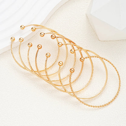 “7-piece gold bracelets set: punk heart designs, open bangles, trendy streetwear.”