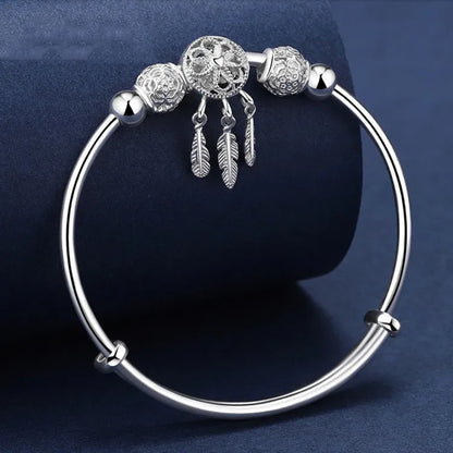 “Silver dreamcatcher tassel feather bracelet, lucky bead bangle, perfect for weddings.”