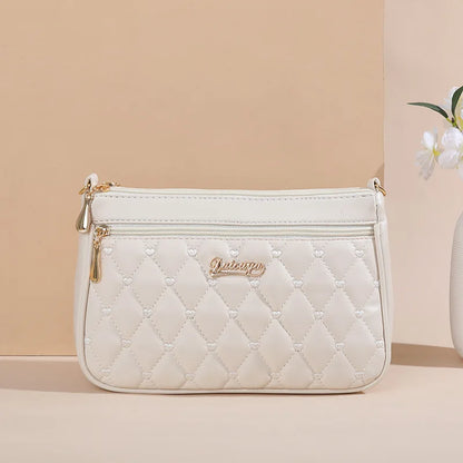 “Embroidered leather handbag for women with hairball detail, stylish and versatile.”