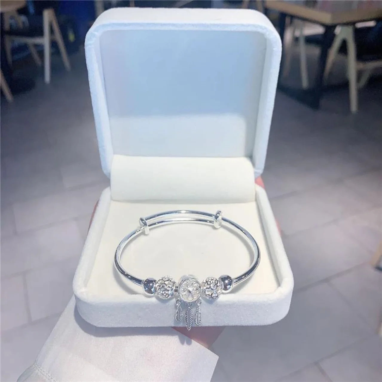“Silver dreamcatcher tassel feather bracelet, lucky bead bangle, perfect for weddings.”