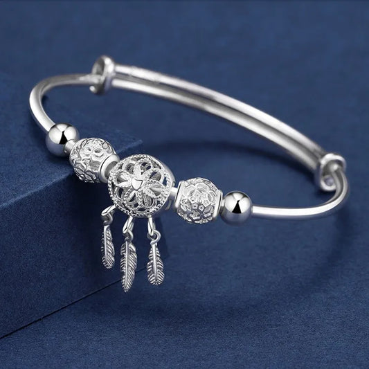 “Silver dreamcatcher tassel feather bracelet, lucky bead bangle, perfect for weddings.”