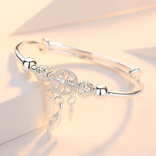 “Silver dreamcatcher tassel feather bracelet, lucky bead bangle, perfect for weddings.”