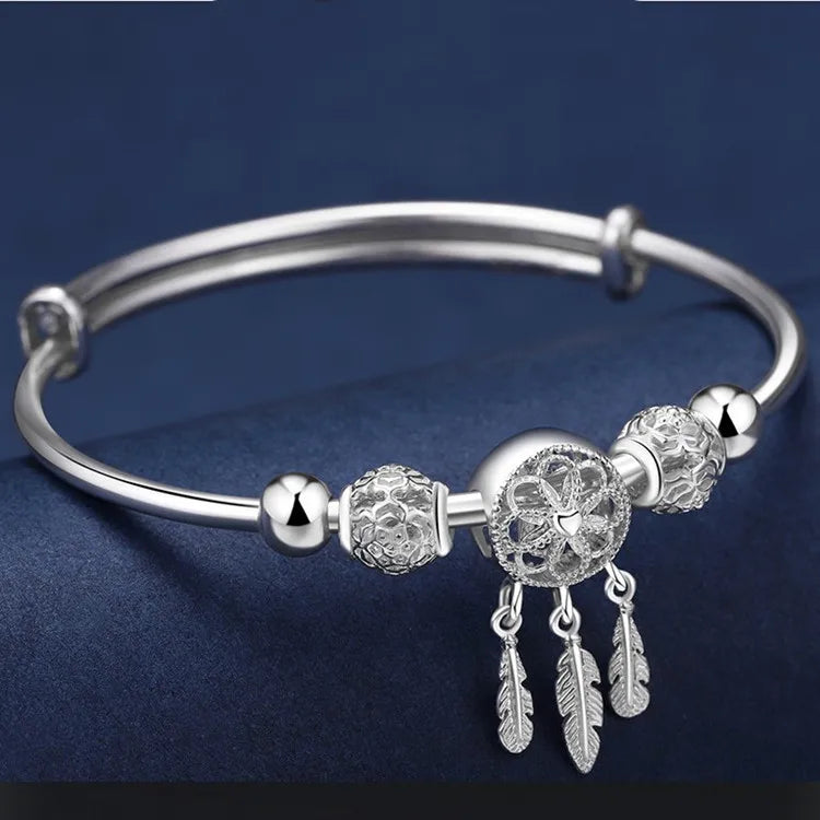“Silver dreamcatcher tassel feather bracelet, lucky bead bangle, perfect for weddings.”
