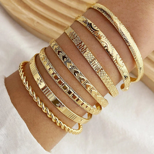 “7-piece gold bracelets set: punk heart designs, open bangles, trendy streetwear.”