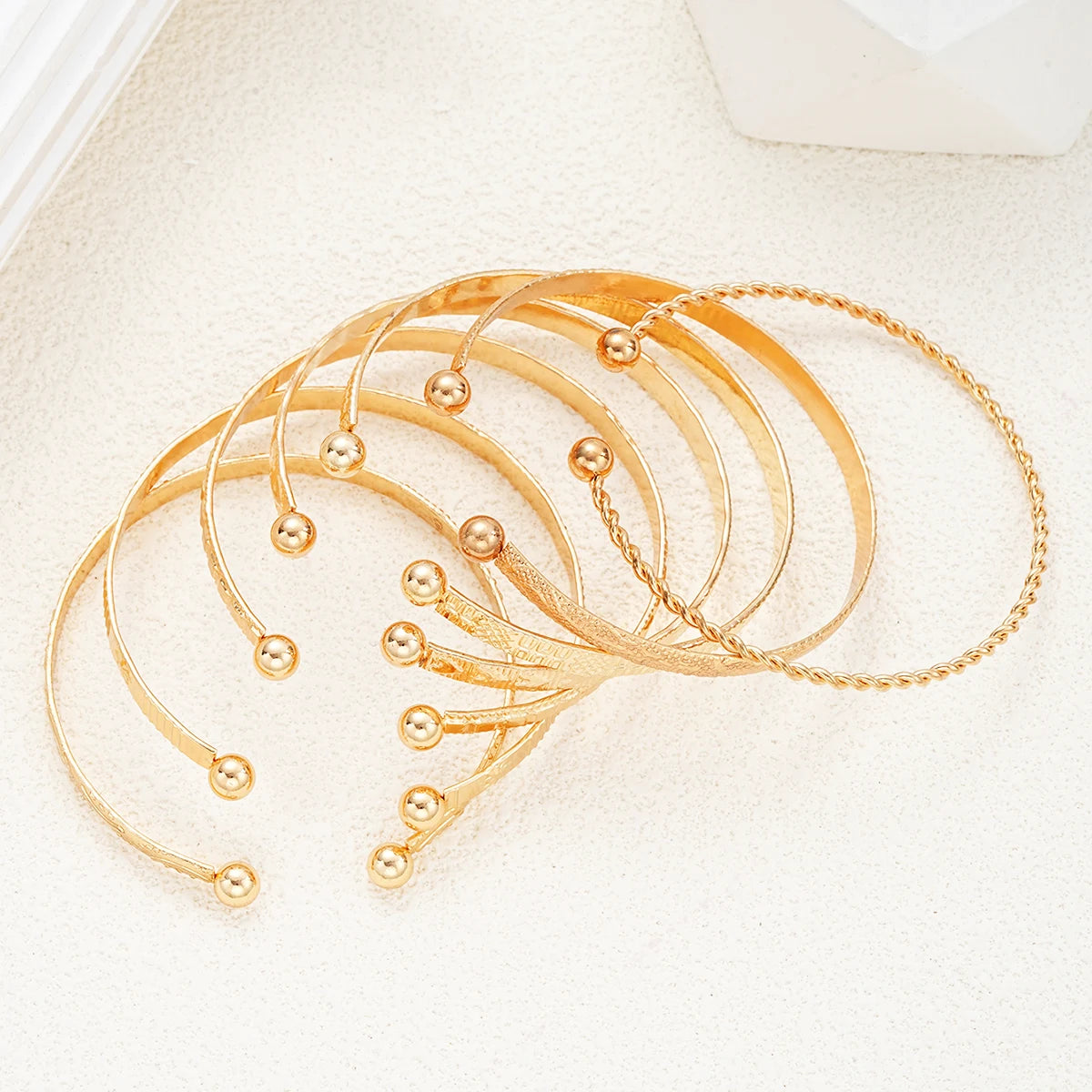 “7-piece gold bracelets set: punk heart designs, open bangles, trendy streetwear.”