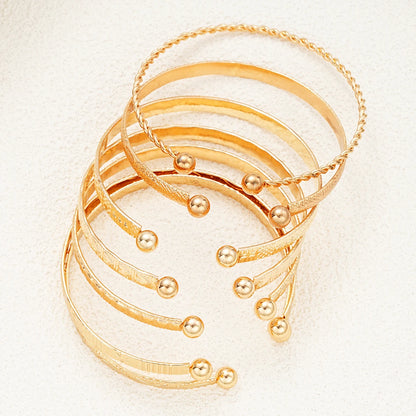“7-piece gold bracelets set: punk heart designs, open bangles, trendy streetwear.”