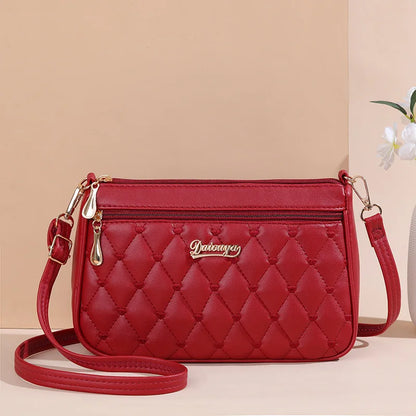 “Embroidered leather handbag for women with hairball detail, stylish and versatile.”