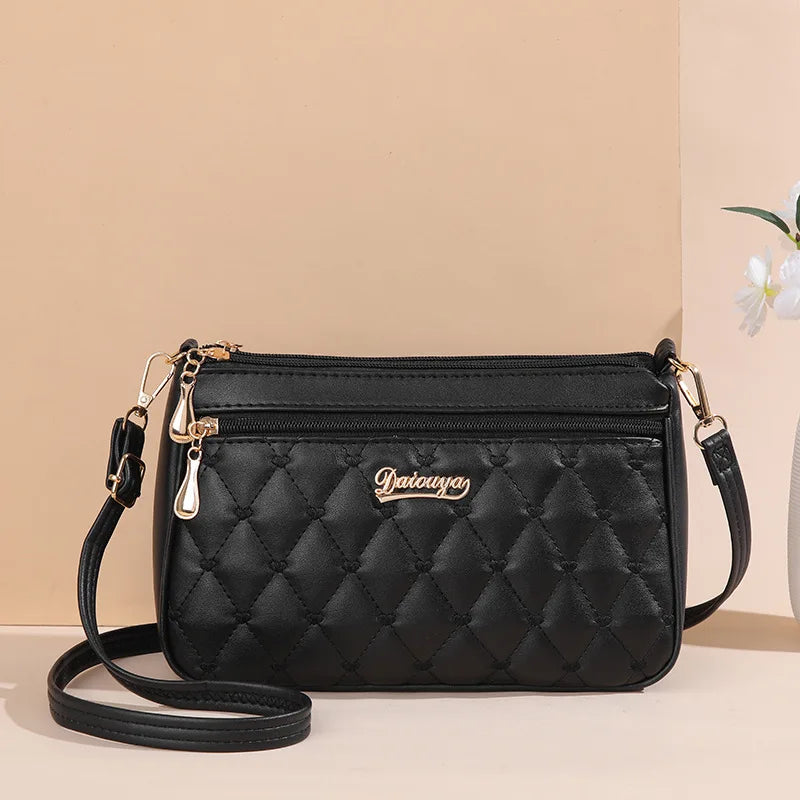 “Embroidered leather handbag for women with hairball detail, stylish and versatile.”